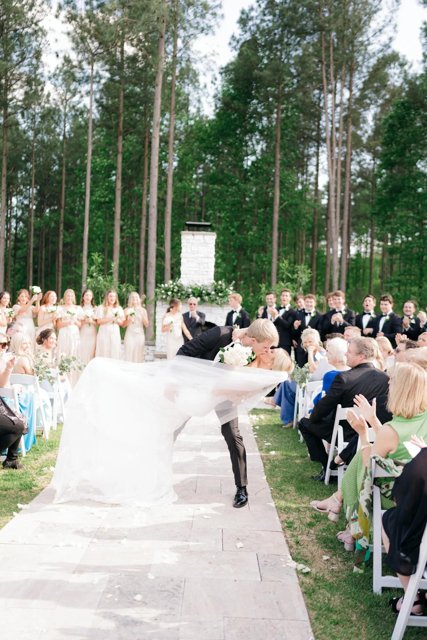 Bride and groom dipping kissing wedding aisle