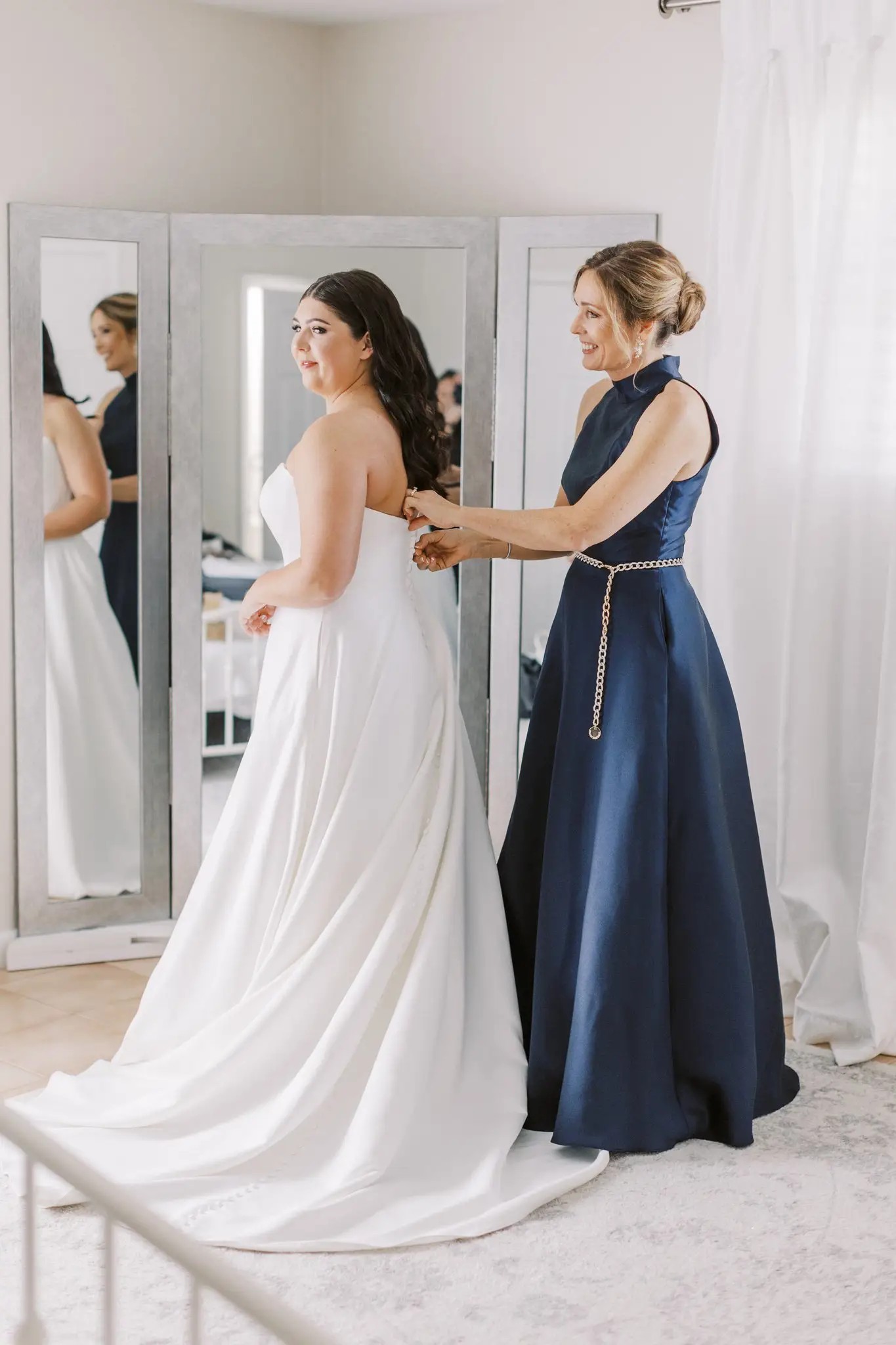 Mother of bride helping zip up gown