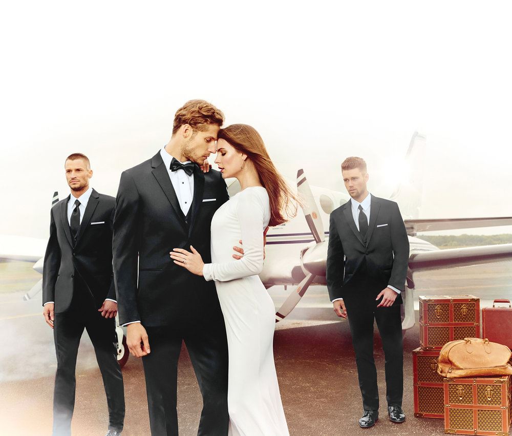 Three male models in black tuxedo and bride in a long sleeve white wedding dress